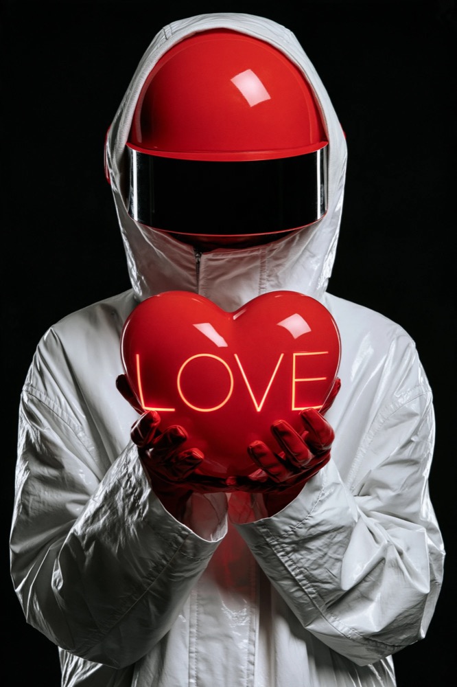 A figure in a white hooded coat and red helmet holds out a red heart with LOVE glowing on it