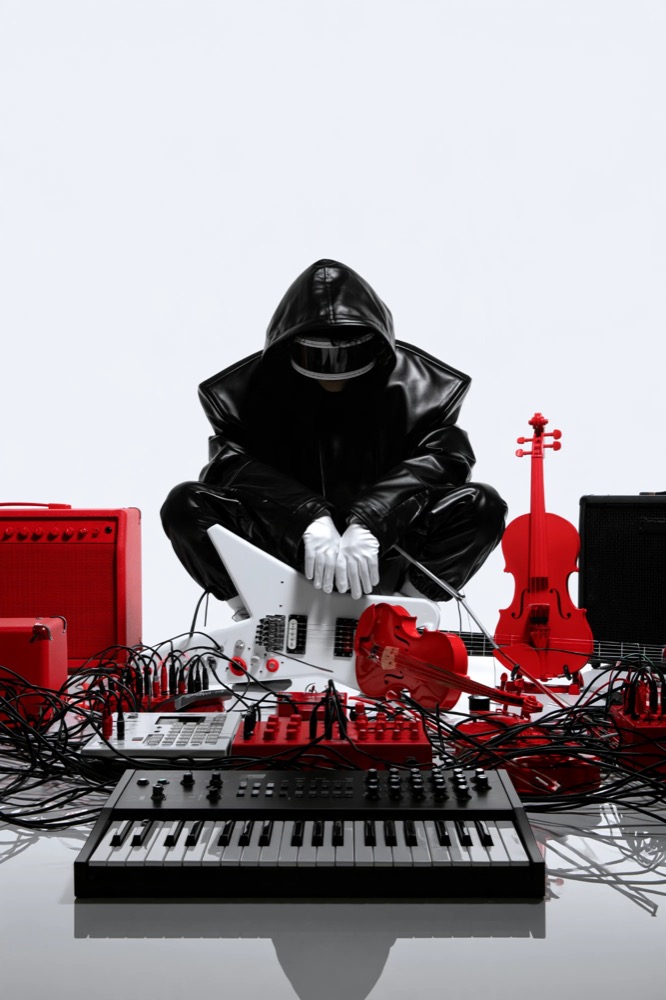 A hooded figure in black leather and white gloves crouches among red amps, red violins, cables and a synthesizer